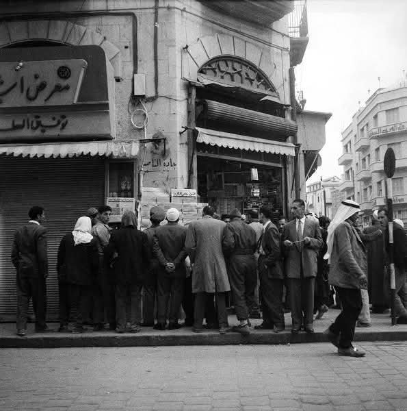 روّاد الصحف ومحبي الجرائد في دمشق يتجمعون صباحاً لقراءة عناوين الأخبار. دمشق 1957